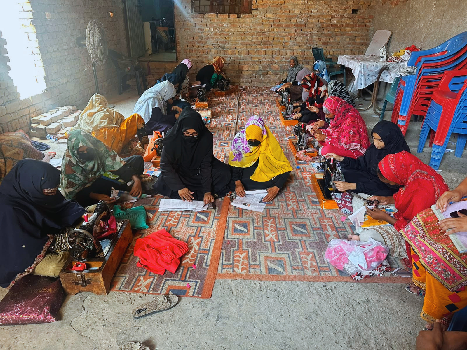 A group of women sitting together during a Jenerosity Sewing Center training session