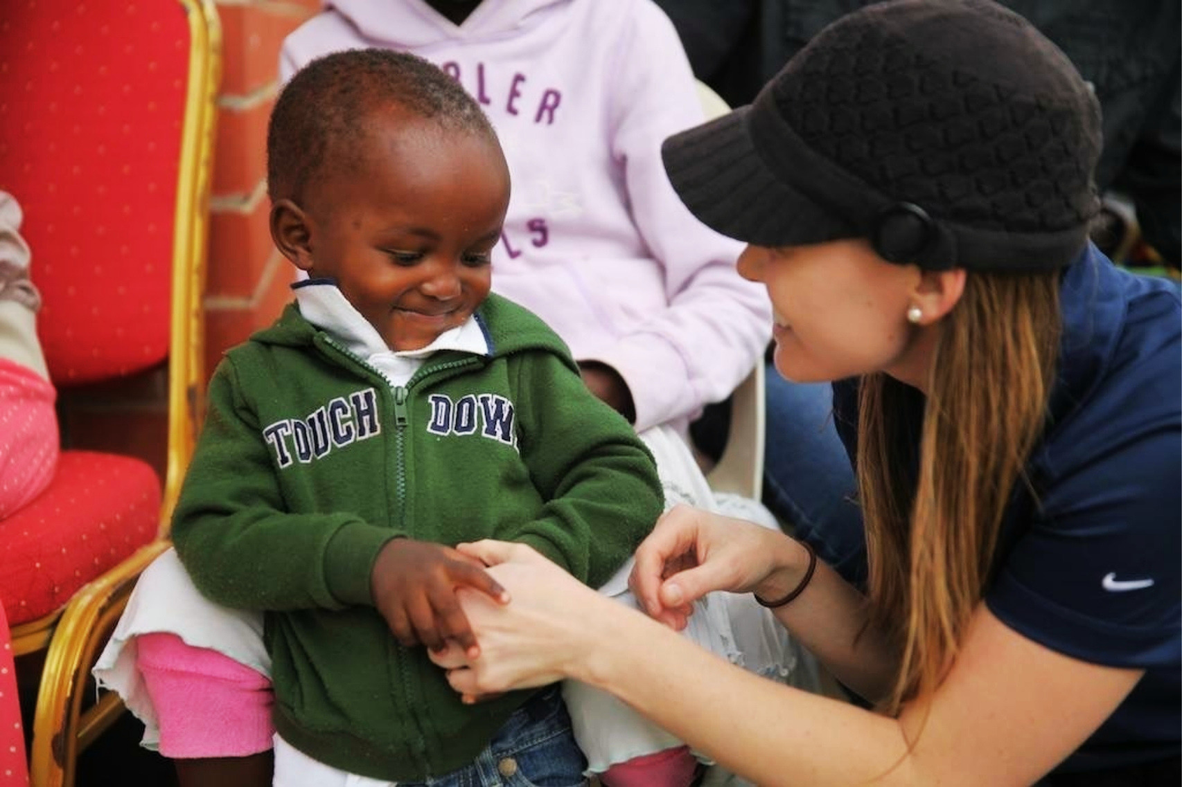 Jennifer Evans smiling with a young boy during a missions outreach