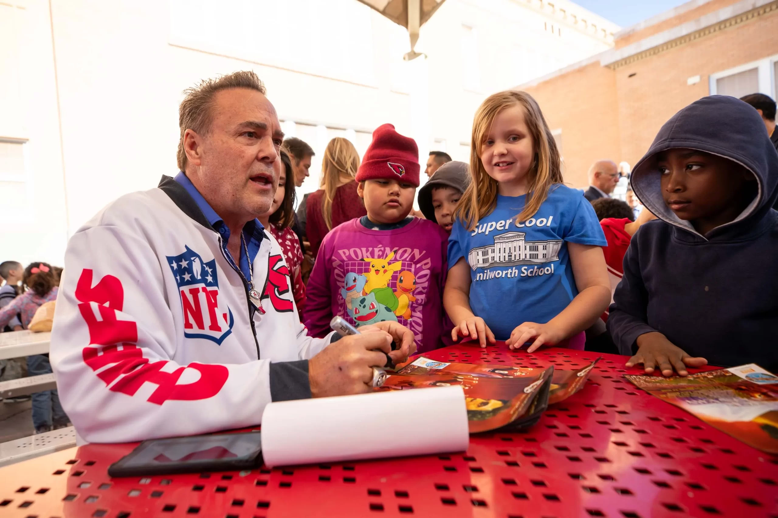 Nick Lowery, former NFL kicker and motivational speaker, signing autographs for children at a school event