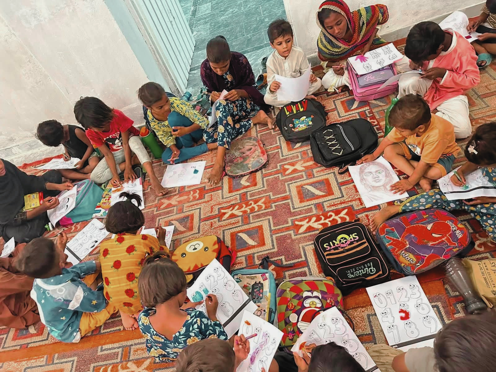 Children sitting together drawing and coloring during the Voice of Grace summer camp